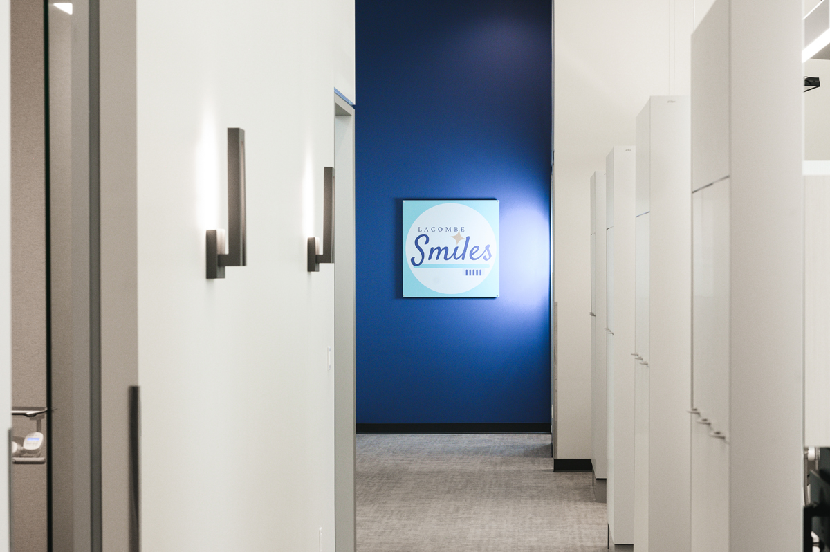 Photo of newly designed Lacombe Smiles Dental clinic in Lacombe, Alberta. The image shows a spacious hallway with 5 patient examination rooms visible through open doors. In the distance, private consultation rooms are visible. Lacombe Smiles Dental offers a range of dental services, including orthodontics and dental implants. If you're looking for a dental clinic in Lacombe, be sure to check out Lacombe Smiles Dental.